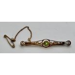 A 15ct seed pearl and peridot bar brooch with safety chain. 3.2gm weight.Condition ReportGood