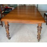 A Victorian mahogany dining table with 2 extra leaves on brass castors and carved turned legs. 215 x