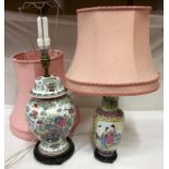 Two Chinese style ceramic table lamps with wooden carved base and pink lampshades, tallest lamp base