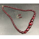 Faceted cherry amber beads and a pair of matching earrings, necklace measures approx 74cm l, drop in