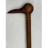 A Pitcairn Island walking stick, the pommel carved as the head of a bird, the cane 87.5cm