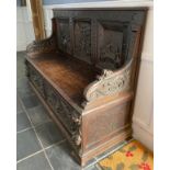 A dark oak continental carved panel backed settle. 107 h x 154 w x 55cm d.Condition ReportLoose