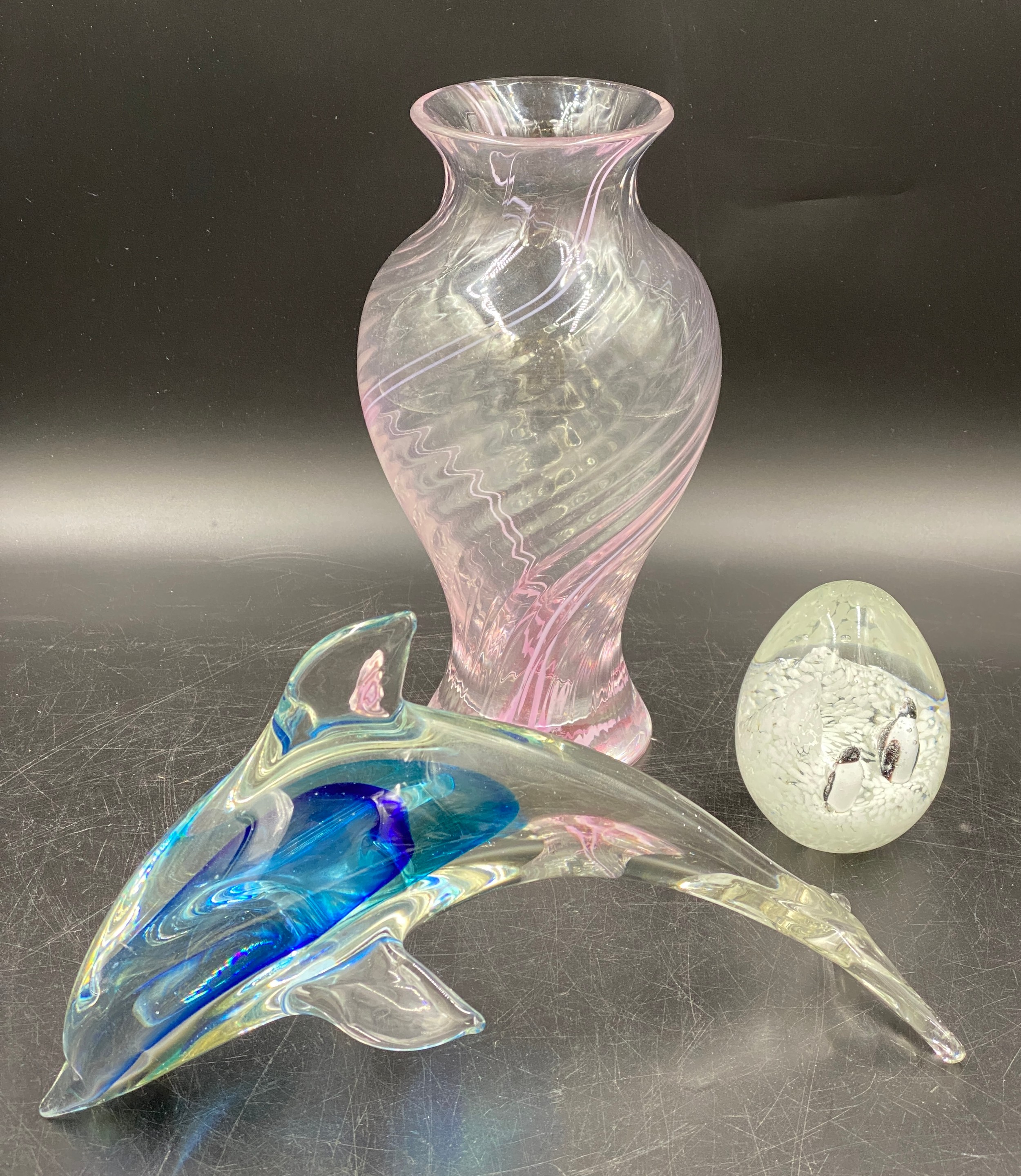 A blue sommerso Murano glass dolphin 26cm l with sticker to base, a Caithness pink swirl vase 25cm h