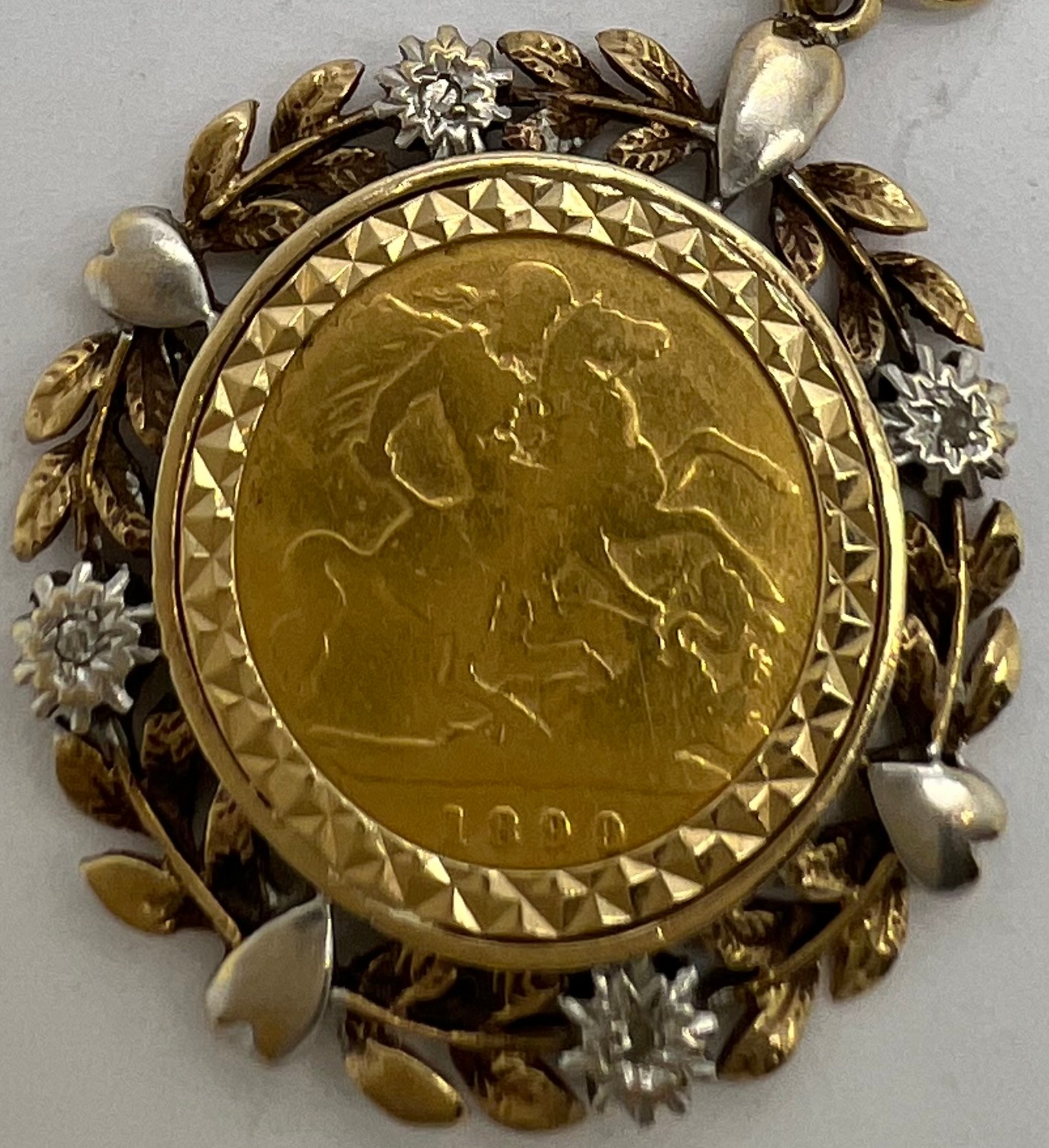 An 1899 half sovereign in a decorative 9ct gold mount. Total weight 8.2gm.