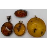 Three amber pendants and a brooch. Two containing insects, largest 3.5cm d.Condition ReportSurface