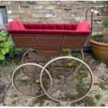 A 19thC wood and iron pram with ceramic handle with recently upholstered interior. 93 l x 48cm w.