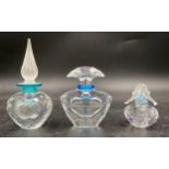 Three Swarovski crystal perfume bottles with stoppers one with dolphins modelled to the stopper,