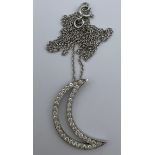 An 18 carat white gold crescent moon pendant, 2.2cm top to bottom set with diamonds on a fine chain