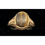 A nine carat gold ring set with tigers eye. Size I. Weight 2.4gm.