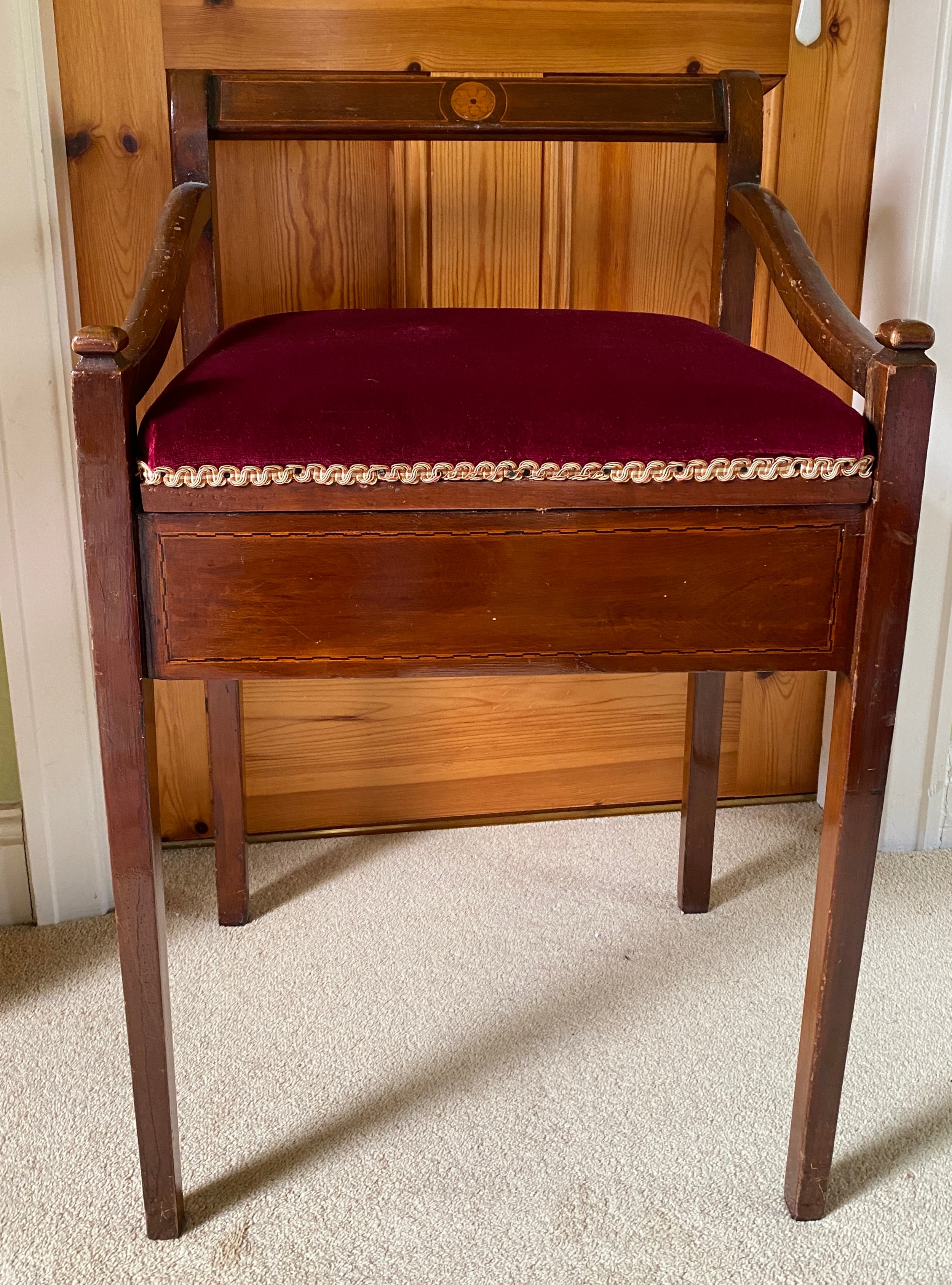 An Edwardian mahogany inlaid piano stool with arms and lift up seat.