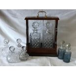 An open wooden tantalus 37 h x 17cm w holding two cut glass decanters with stoppers 26 h x 10cm w