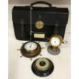 A black brief case with E.R. monogram and key along with two aneroid barometers and a thermometer in