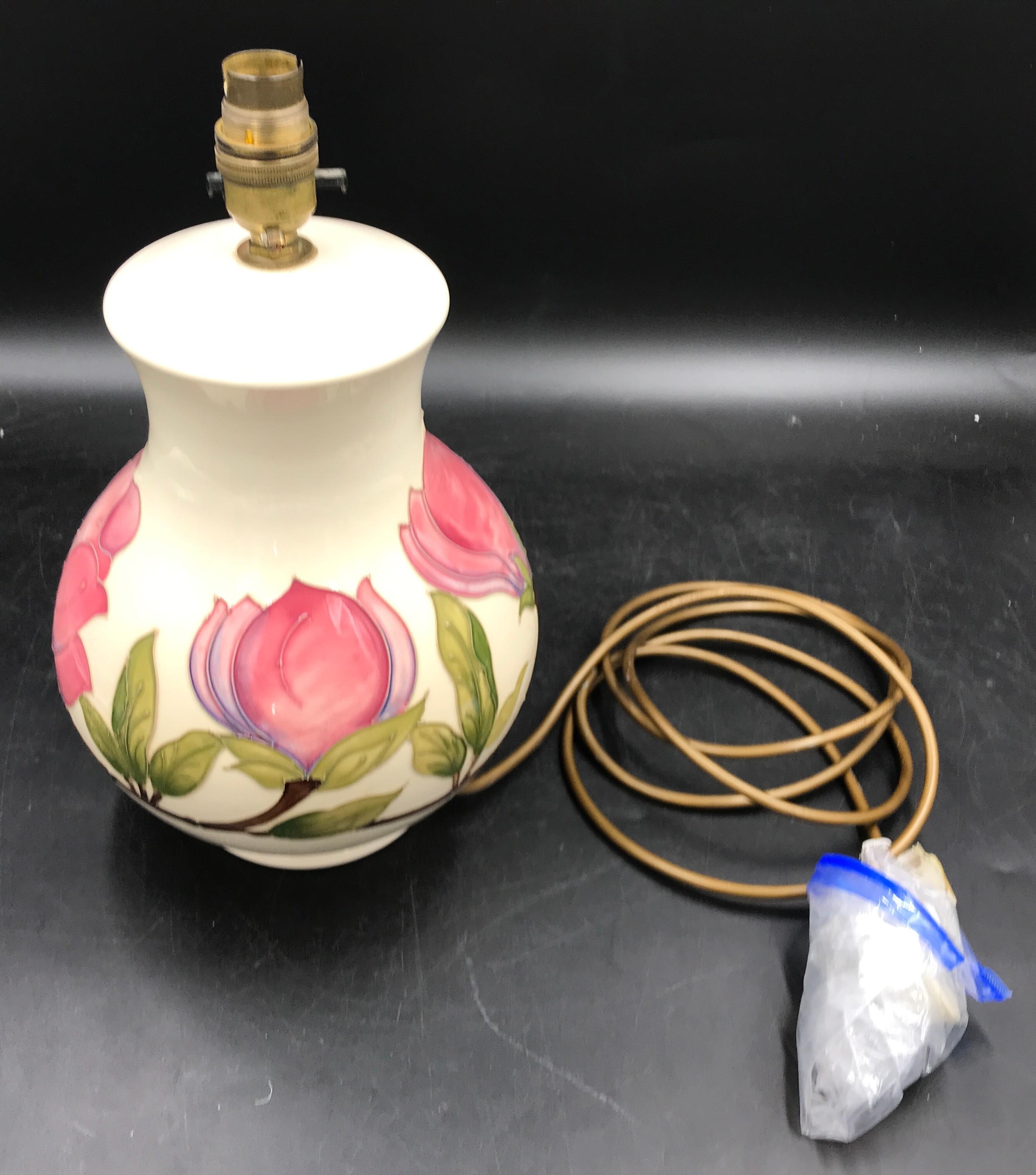 A Moorcroft pottery table lamp decorated with Magnolia design on a cream background, 32 cm h to