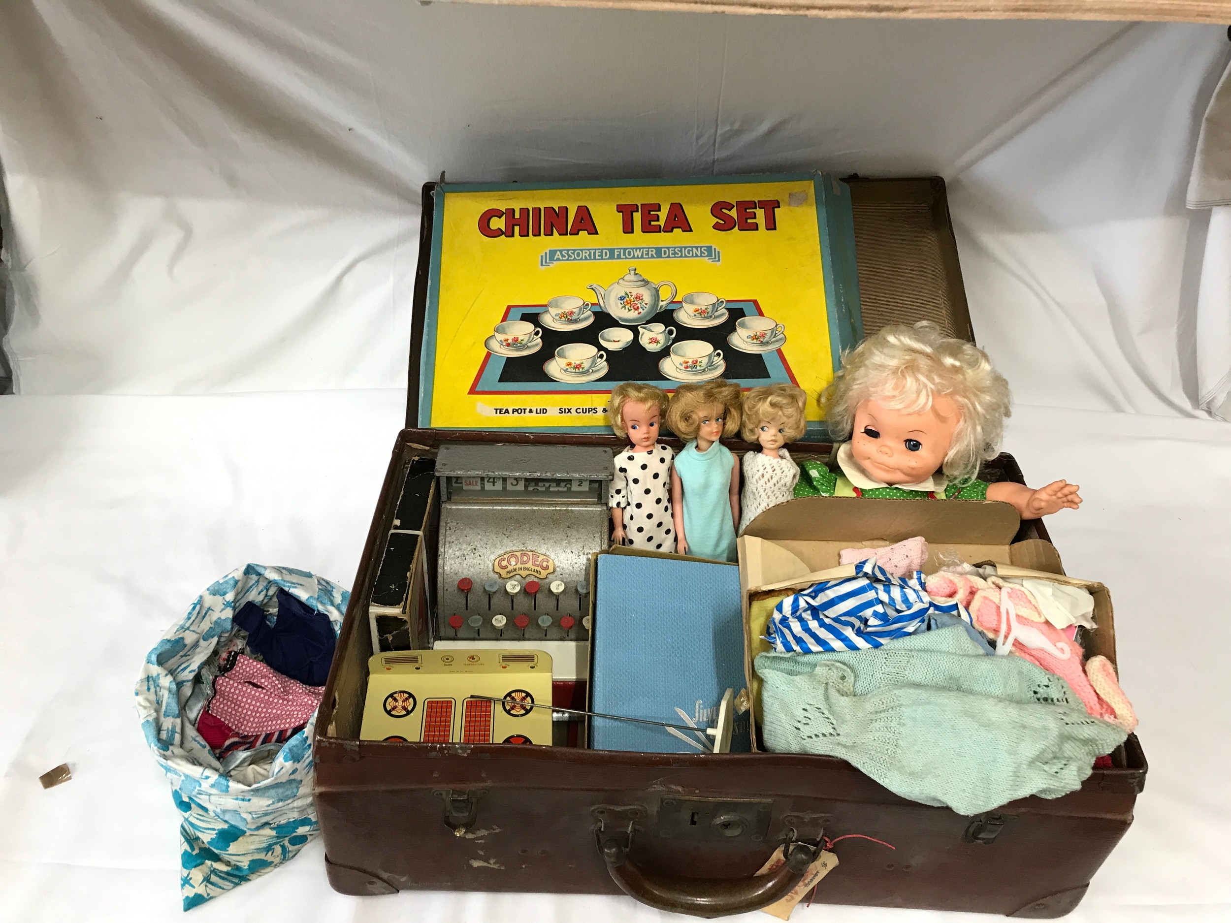 A suitcase full of children's toys to include four dolls, one Laughing Fofi, three unnamed, clothes,