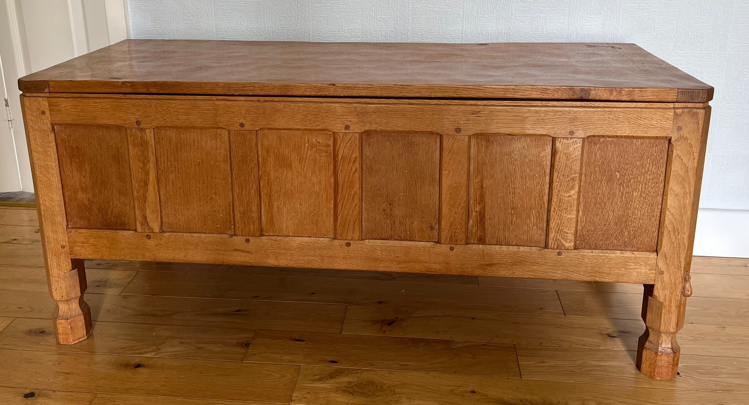 A Robert Mouseman Thompson panelled oak blanket box with hinged top on short octagonal baluster