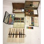 Six water colour sets one Daler-Rowney along with a collection of brushes.