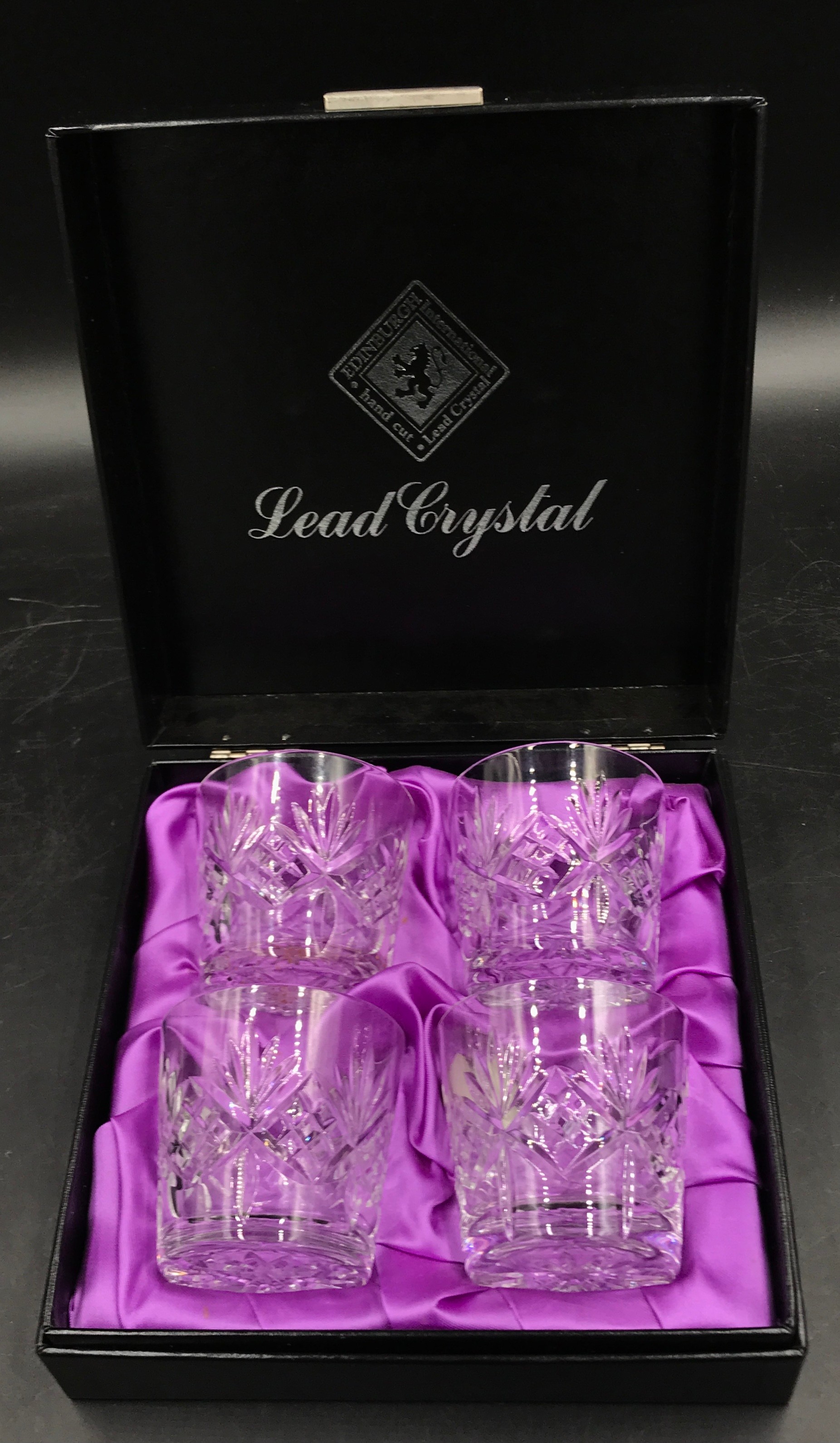 A boxed Edinburgh International hand cut set of four lead crystal glasses.