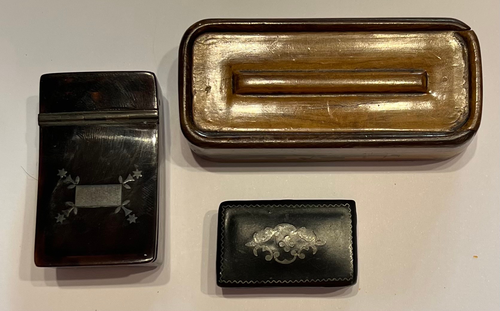 Three snuff boxes including tortoishell pique, papier-mâché and wooden.