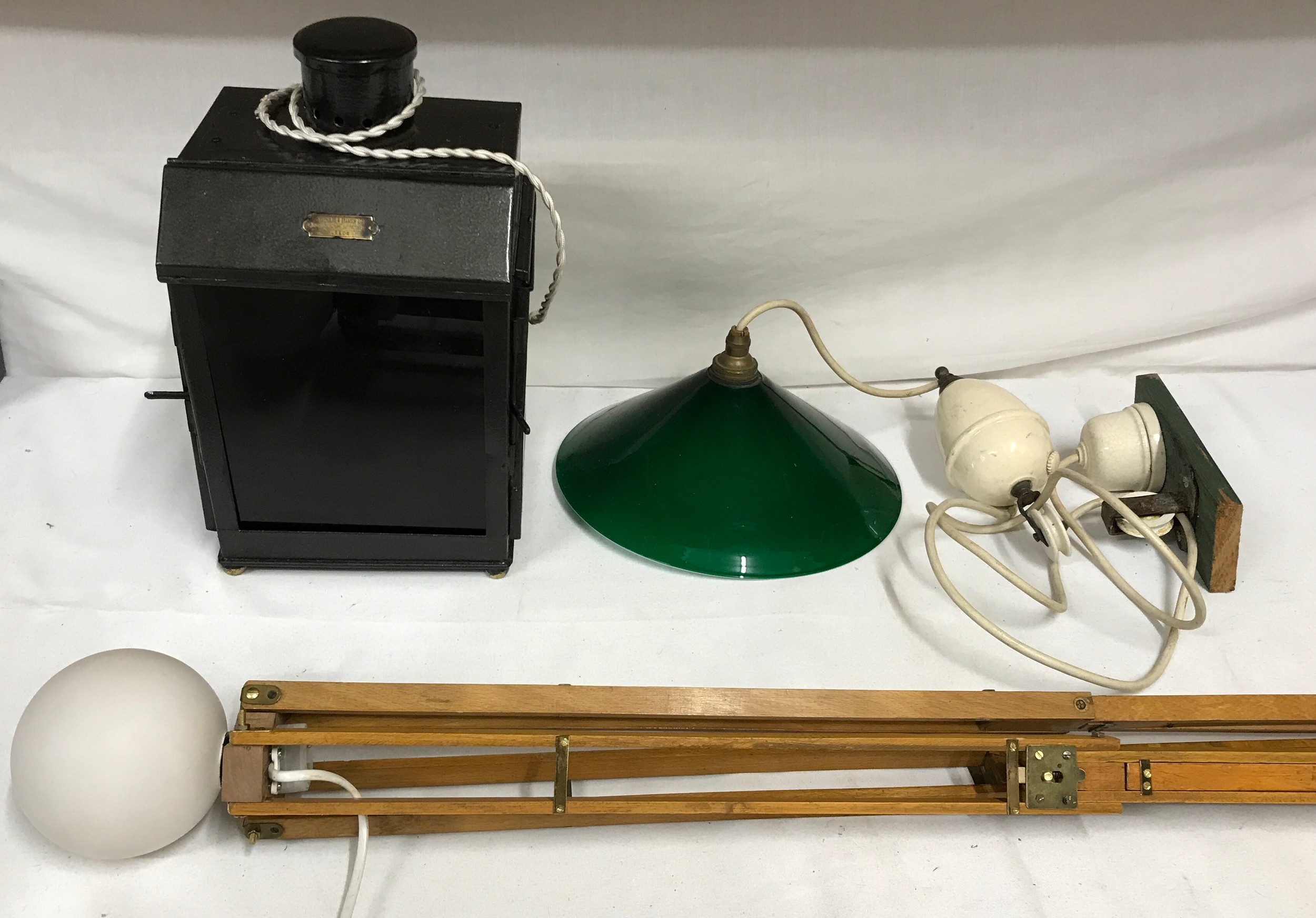 Three pieces of lighting a converted darkroom lamp with oil burner with retailer's plate for '