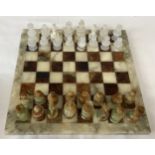 Onyx chess board and pieces, board 36cm square, King 7cm h. Pieces in a Simmers Biscuit Tin.