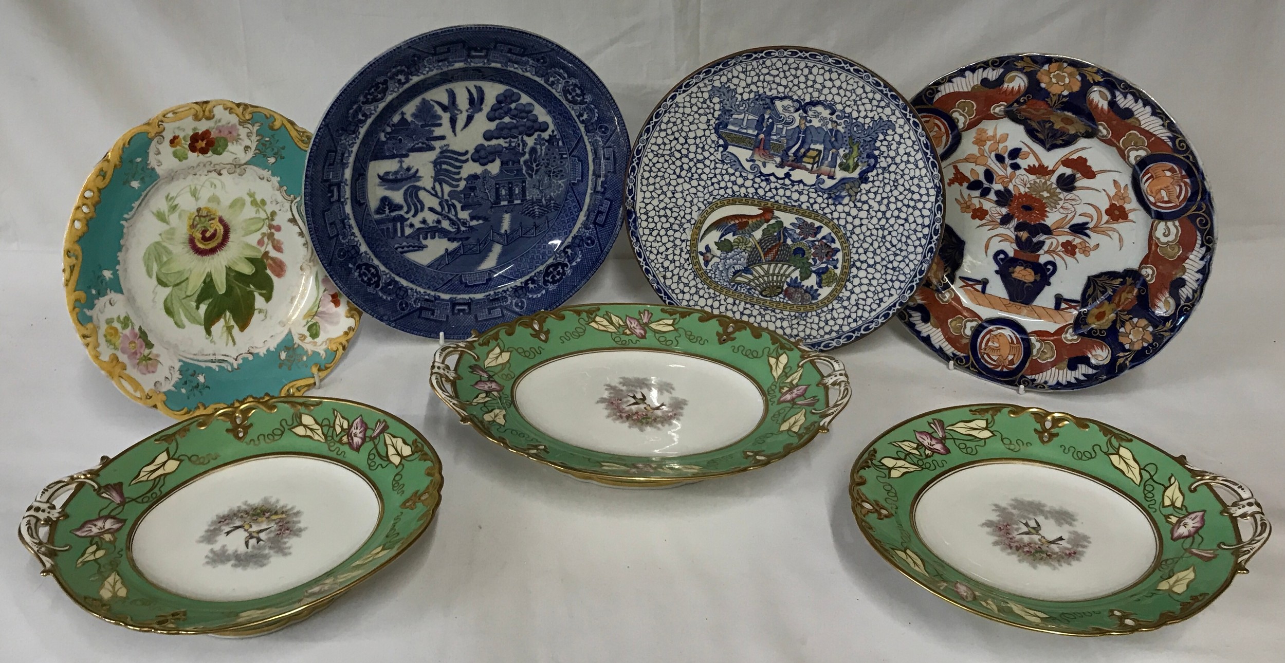 Seven ceramics to include 4 plates and three tazzas. The tazzas are green and white and two have one