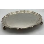 A silver tray raised on scroll feet. Weight 458gm. 25cm d. Sheffield 1960 maker William Bush and son