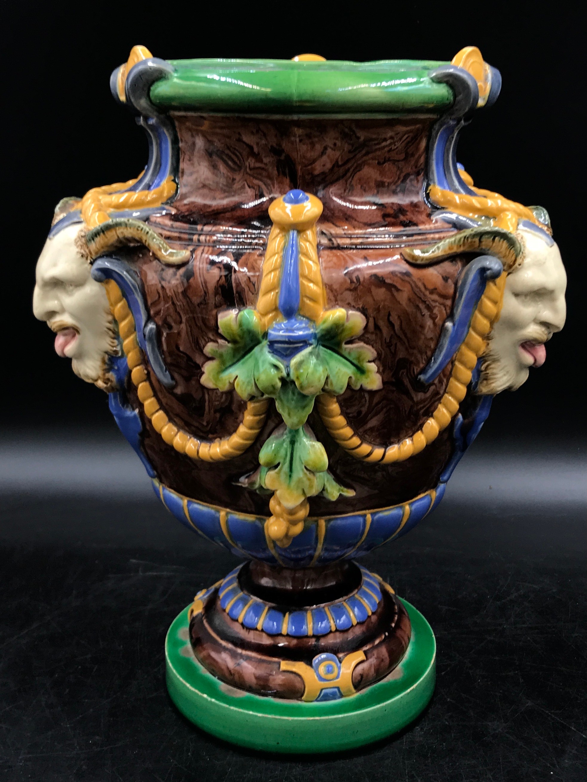 A Minton majolica "Bacchus" vase applied with three satyr masks on a circular base, impressed