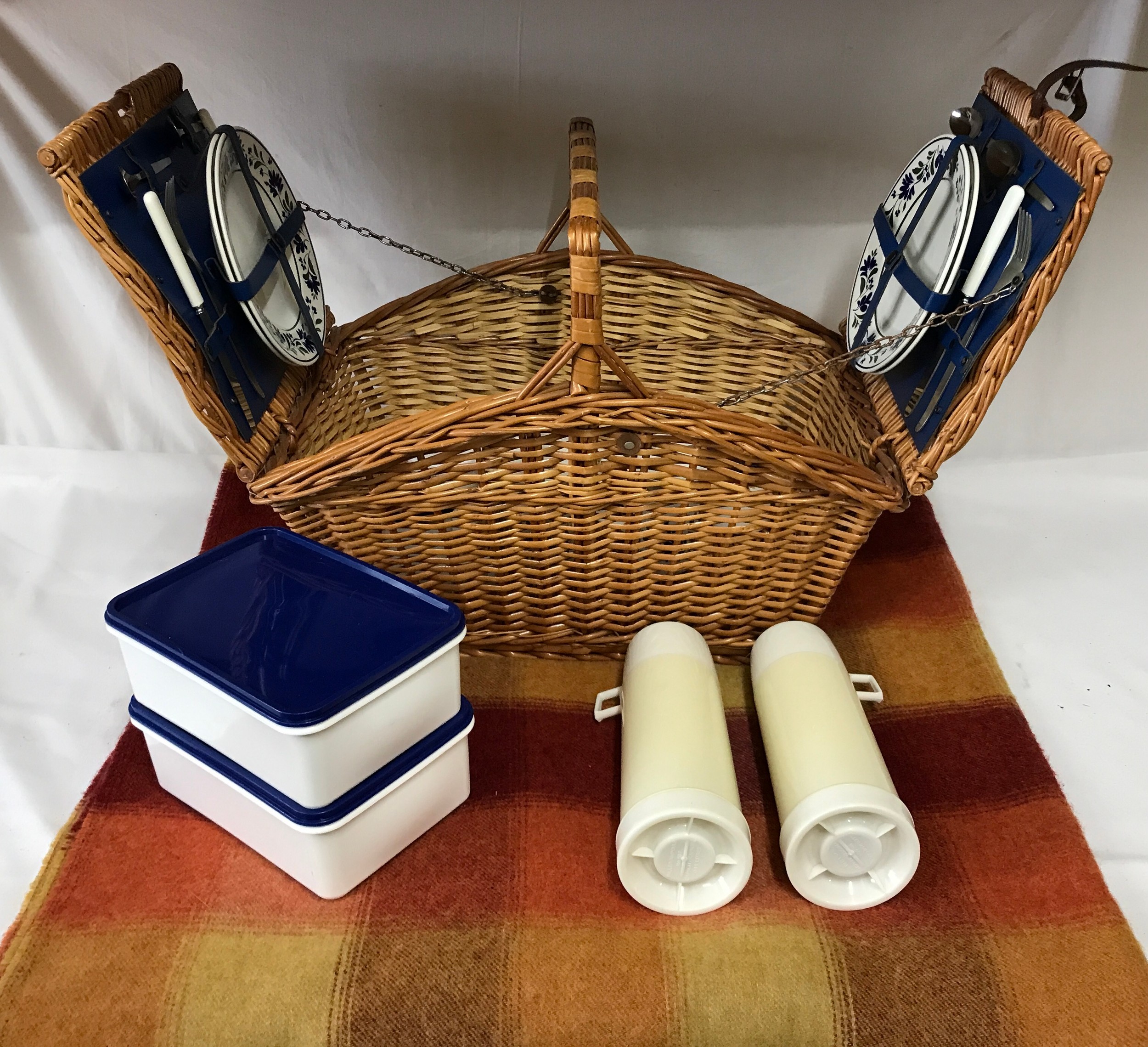 Double lidded picnic basket with a fitted interior for two people comprising cutlery, plates, cups