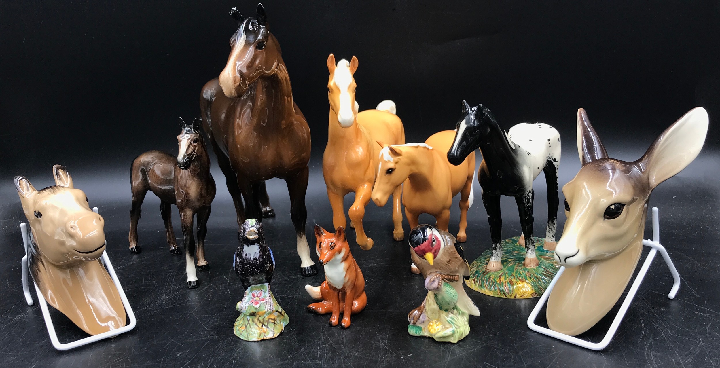 A collection of ceramic animals to include a Royal Doulton black horse, W.R. Midwinter deer faun