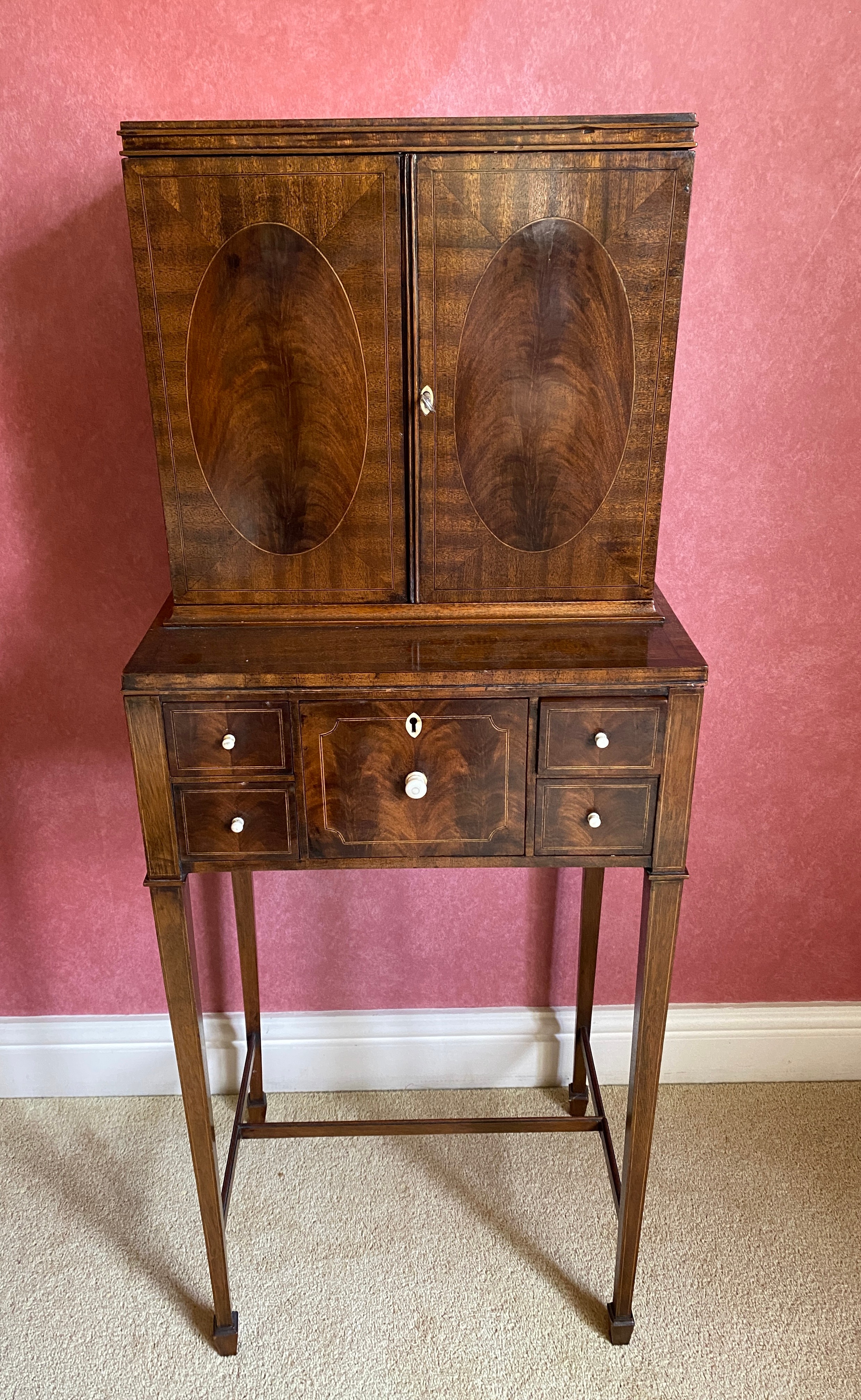 An Edwardian mahogany inlaid cabinet, 2 doors over 4 drawers on square tapered legs. Ivory