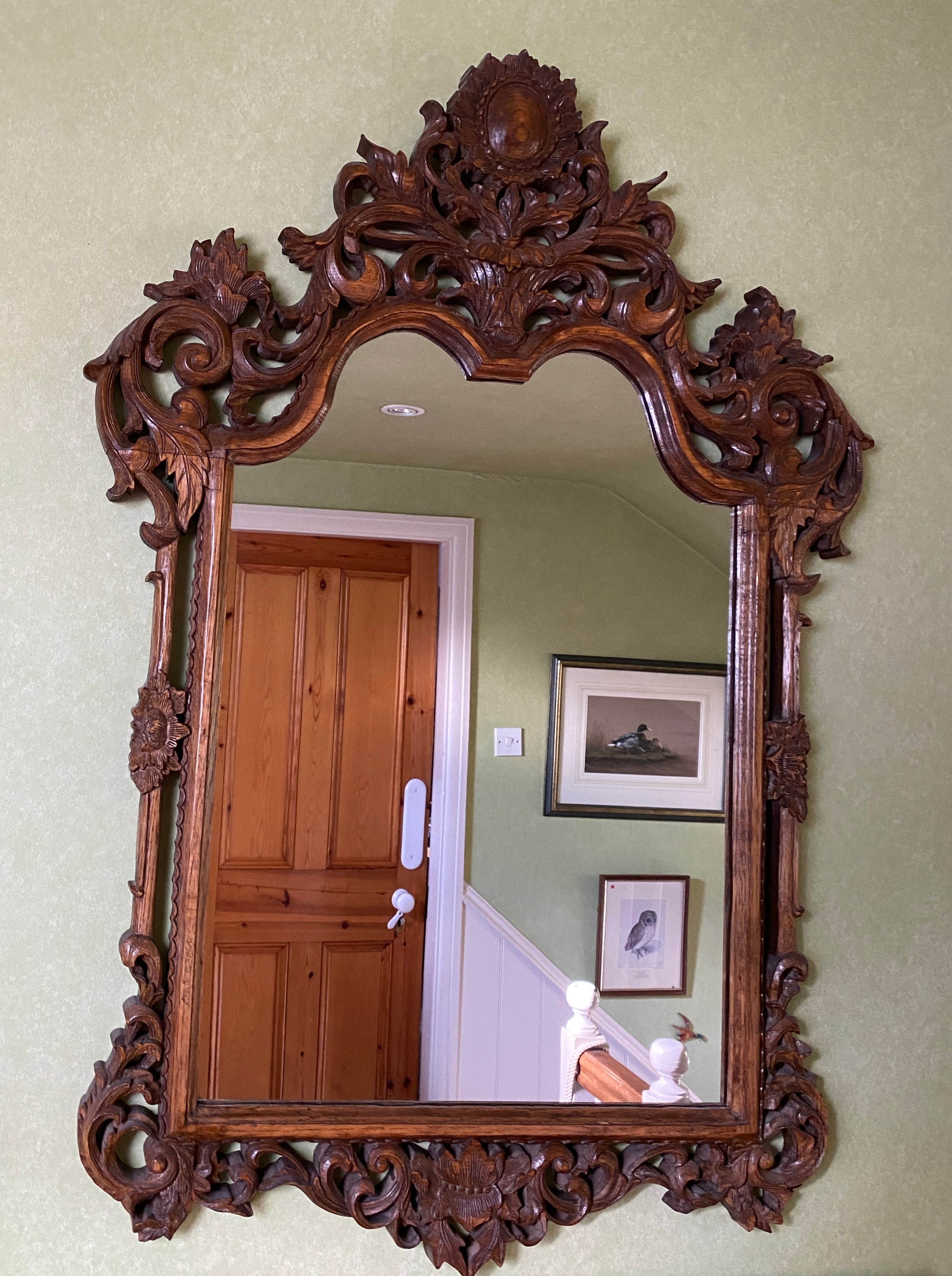 A decorative carved oak wall mirror.