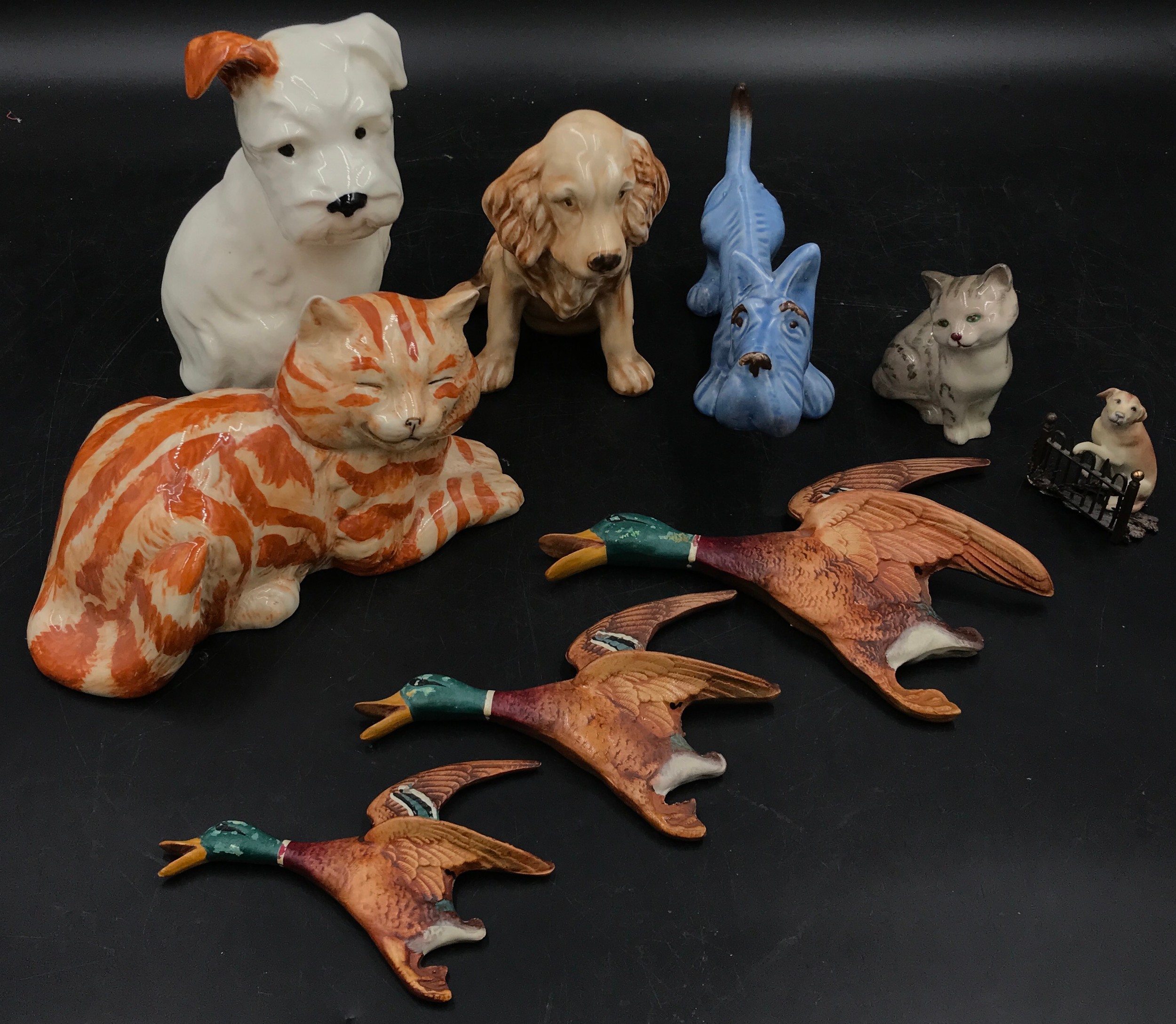 A collection of ceramic animals to include a blue dog and two other dogs, a Just cat and a Royal