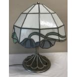 A heavy metal table lamp with a Tiffany style shade and an industrial style base. 57cm h x approx.