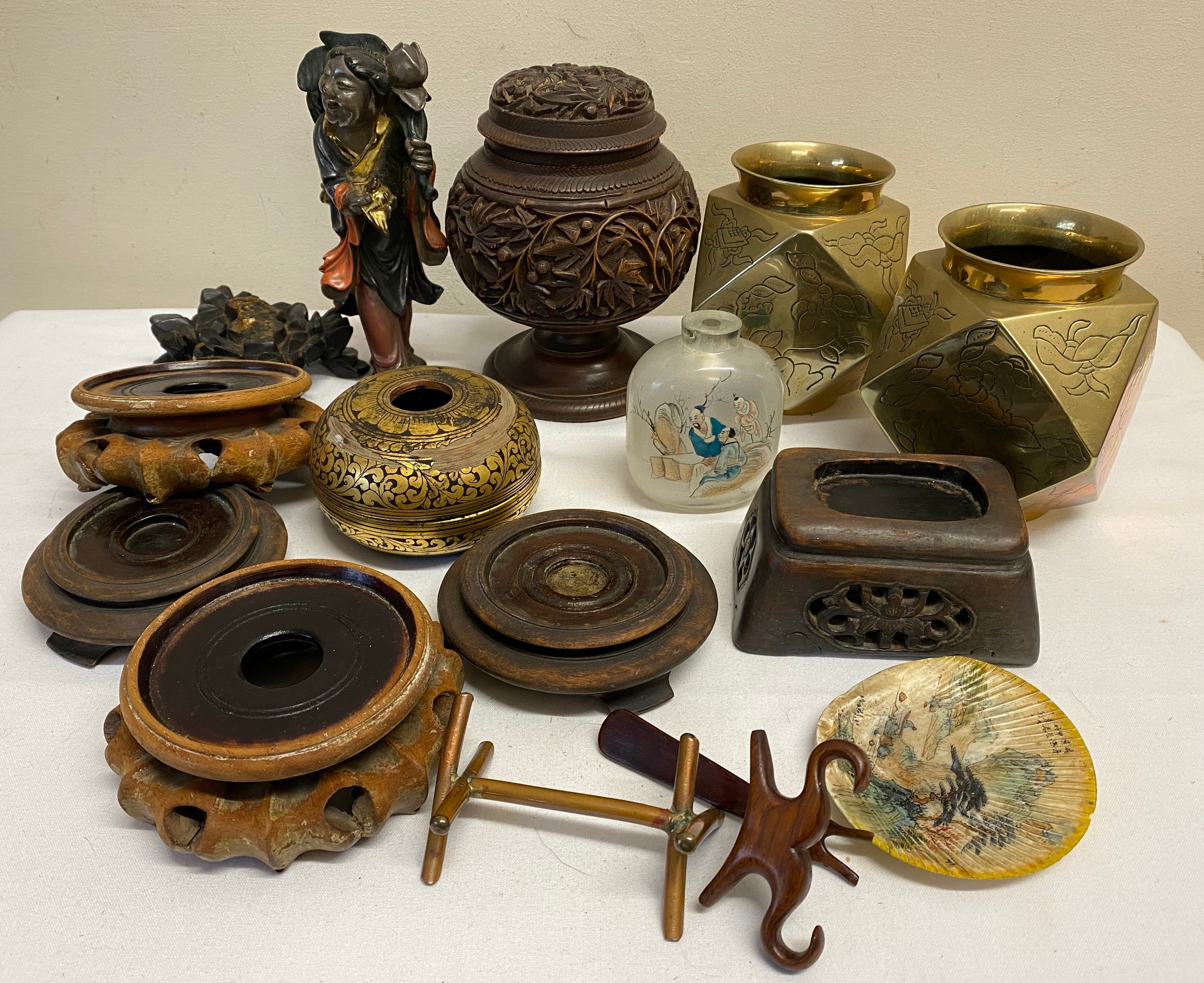 Oriental items to include a pair of brass faceted vases, hard wood stands, a carved wooden lidded