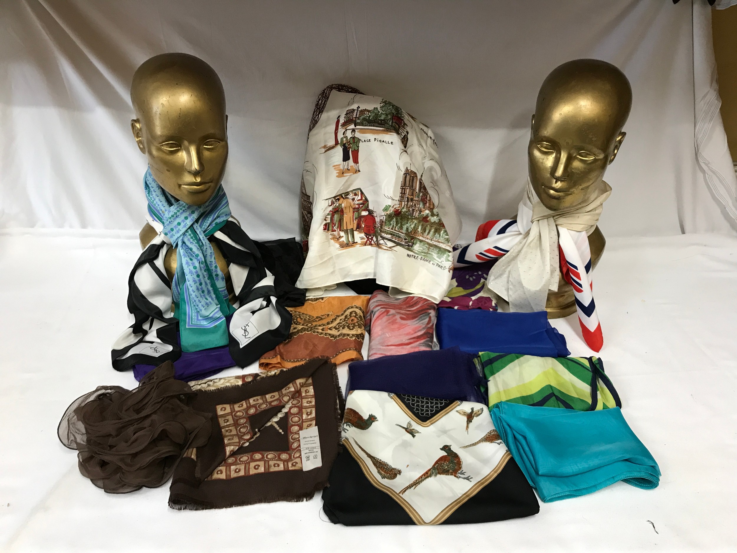 Seventeen head scarves one YSL, one Berkertex, one depicting Paris, one commemorating the Royal