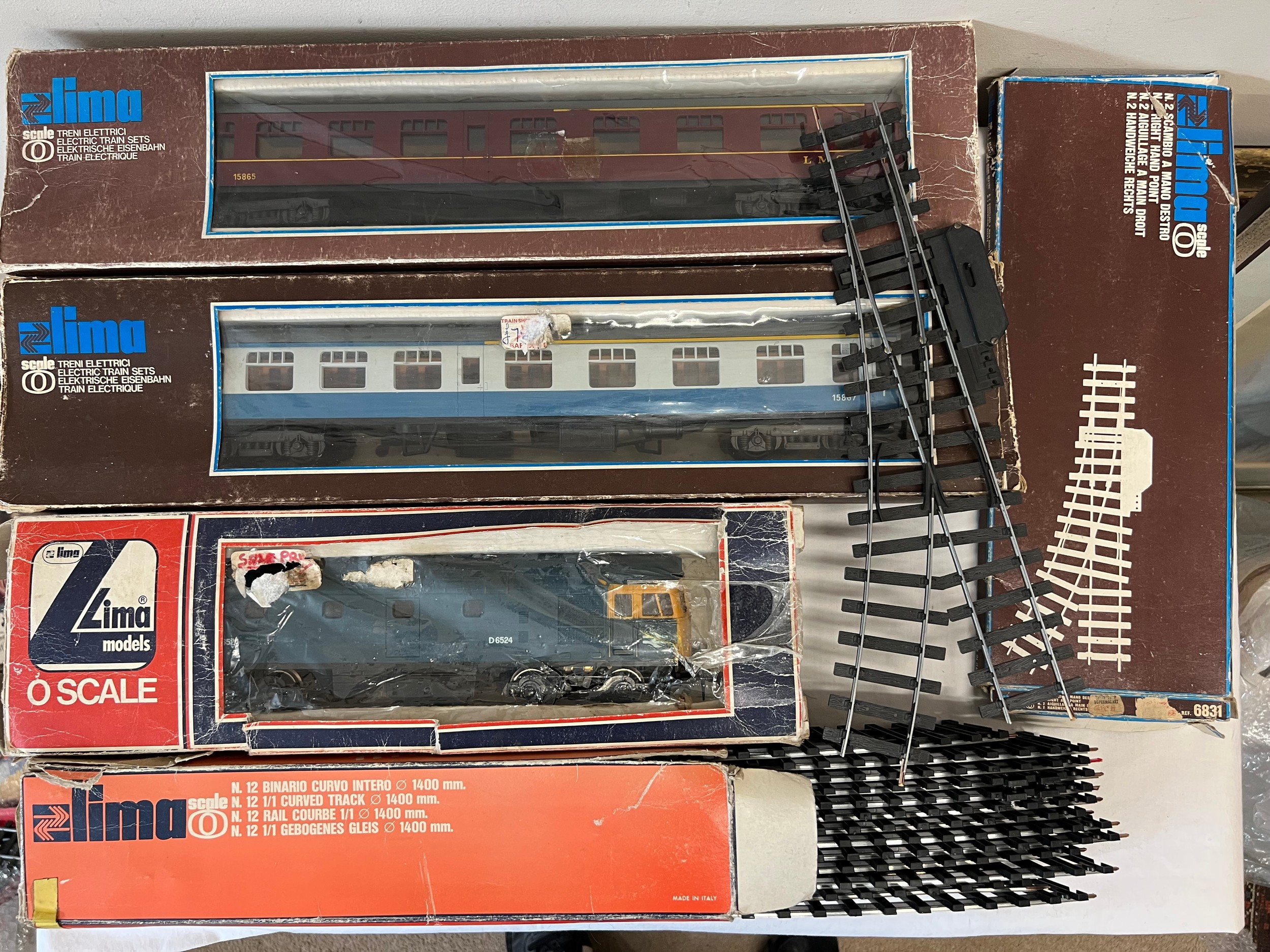 A collection of boxed Lima O Gauge trains and track to include LMS 15865 coach, 15867 coach,