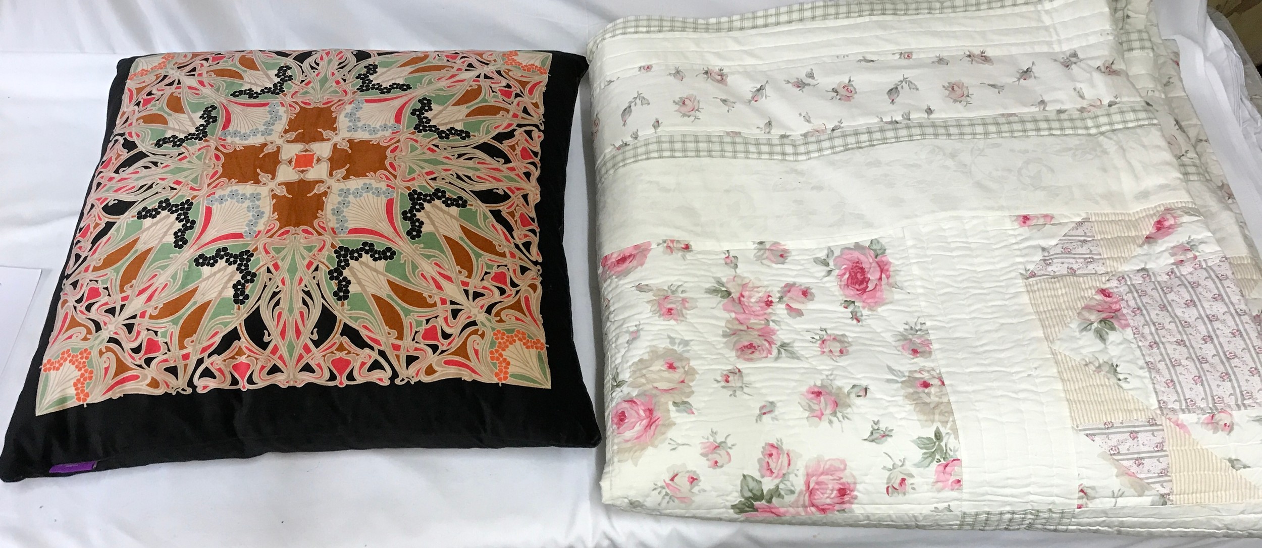 A contemporary part patchwork style quilt with printed patchwork design in pinks and greens approx