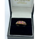 A nine carat gold ring set with three garnets. Size N. Weight 1.9gm.