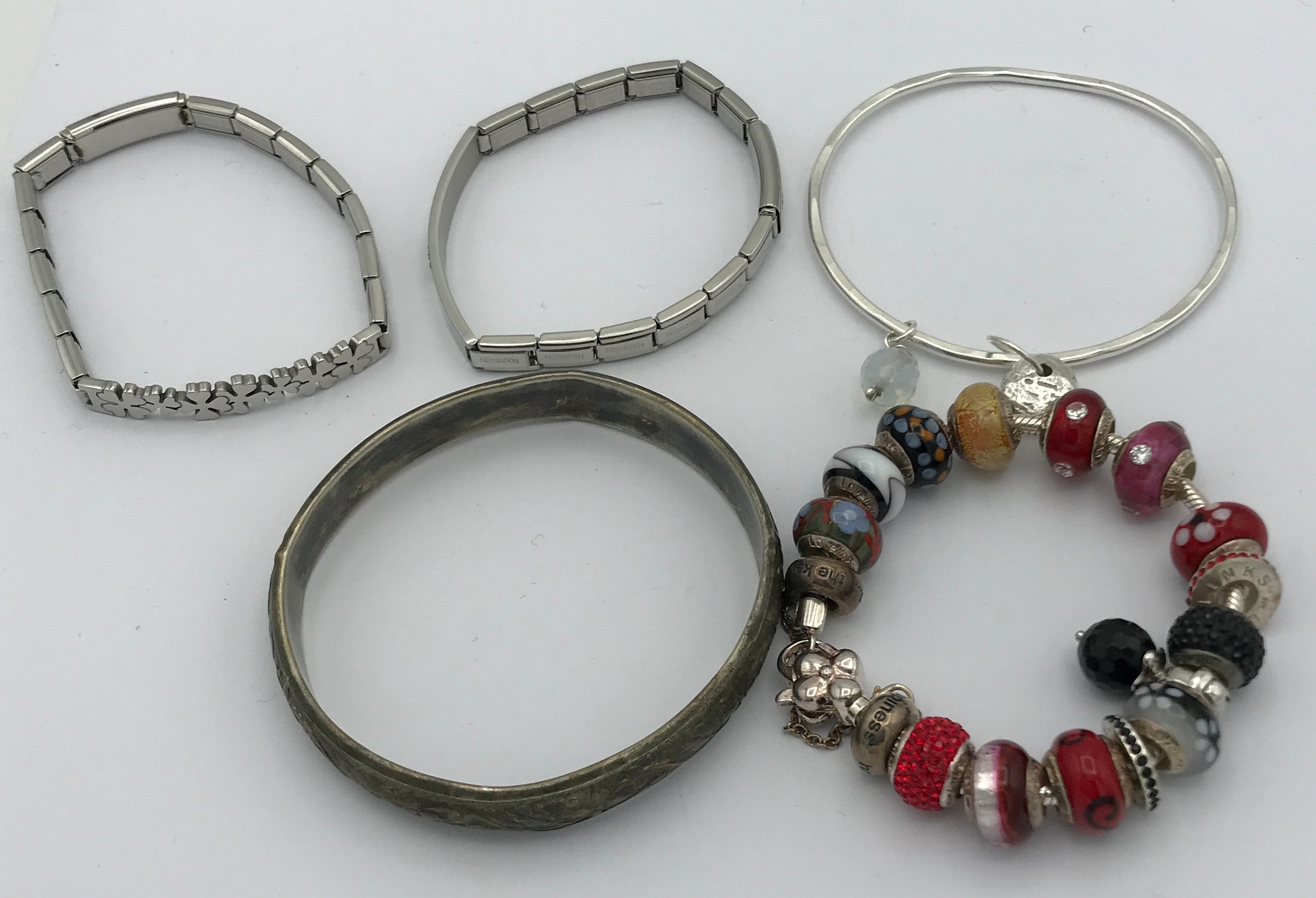 A selection of five bracelets to include two Nomination bracelets, a Pandora bracelet with 3 spare
