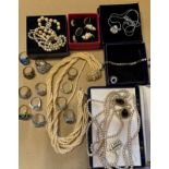 A quantity of costume jewellery to include faux pearl necklaces, silver cocktail rings etc.
