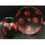 Poole pottery to include a black plate and vase both with red lava drip pattern. Plate 26.5 w and