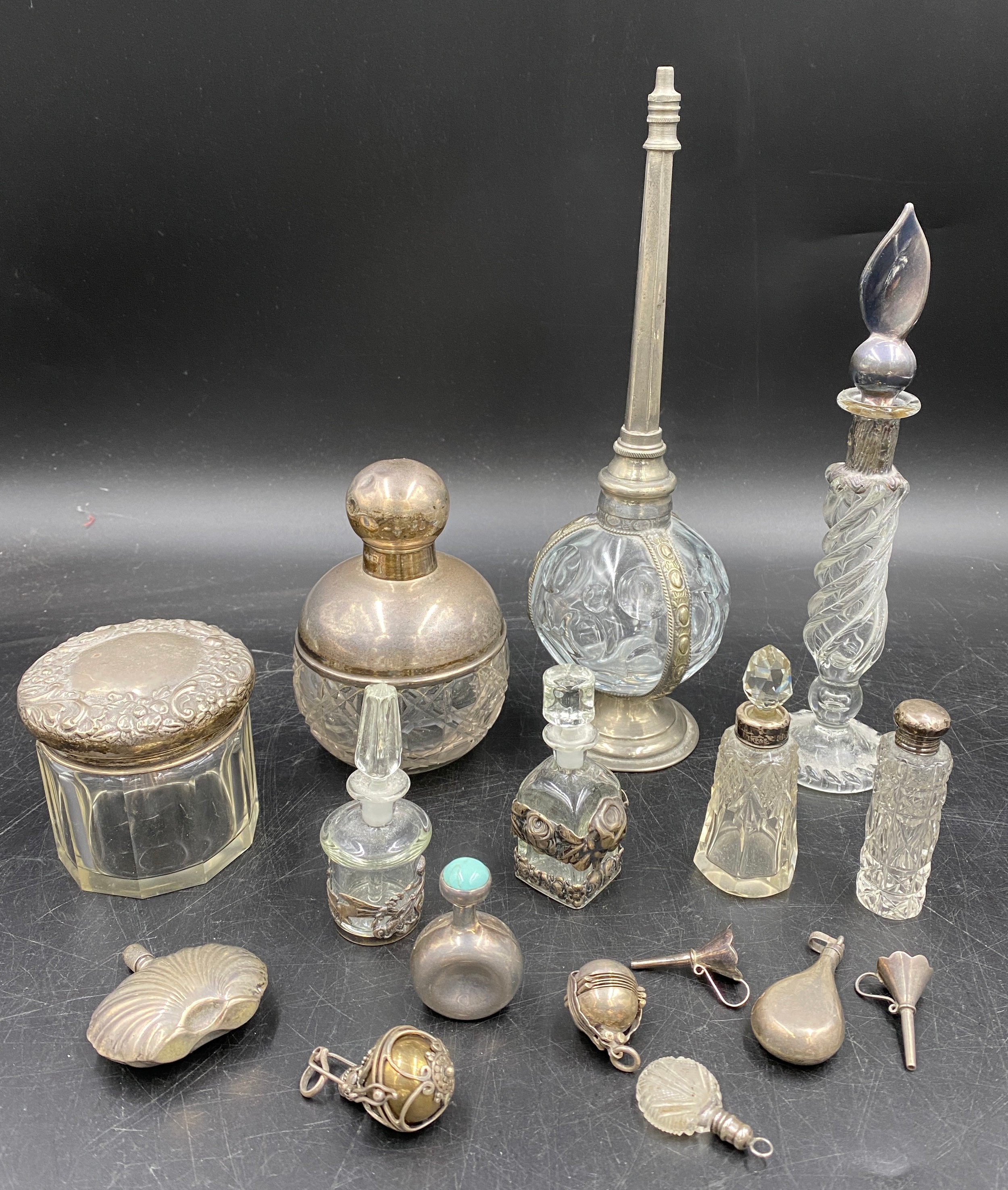 A collection of silver and glass items to include four perfume bottles, perfume pendant, perfume