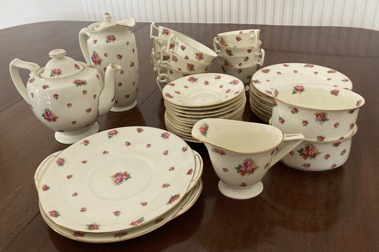 A Royal Doulton tea service with rose pattern and gilt edges comprising: 12 x cups and saucers,