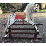 Rocking horse on wooden base, dappled grey with tan leather seat, approx. 122cm long x 99cm high.