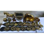 An assortment of brass to include horse brasses on a strap, horse and cart etc.