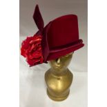 An asymmetric cloche hat in red velour and floral embellishment by Philip Treacy London.