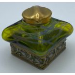An Art Nouveau inkwell with green iridescent glass and brass hinged cover stamped DRGM 168180