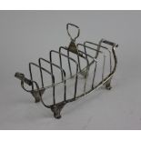 A George III silver toast rack boat shape with six divisions (a/f) and two scroll handles on four