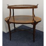 An Edwardian rosewood and inlaid two-tier graduated etagere, the oval cross banded top with lift-off
