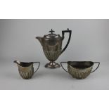 A George V silver three piece coffee set by Walker and Hall to include a coffee pot Sheffield 1915